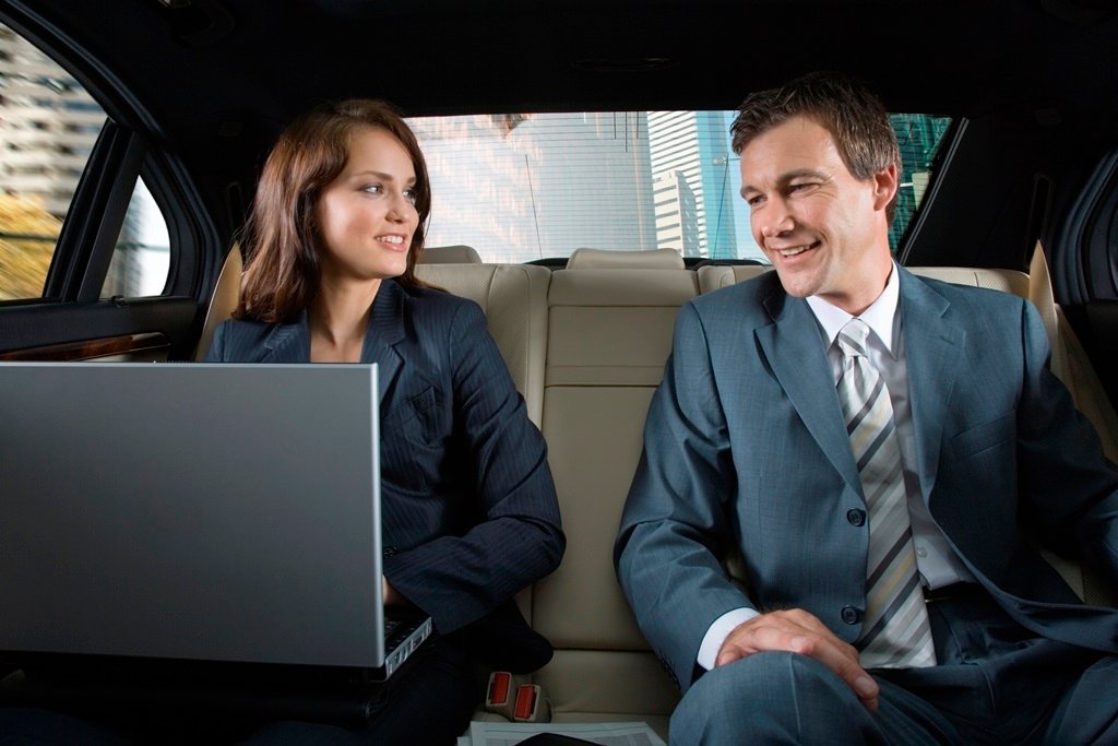 Business travellers relaxing in the back of an Airport Limo Hamilton vehicle